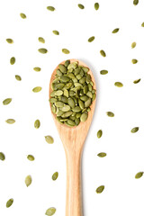 Pumpkin seeds and wooden spoon on white surface. Concept of healthy eating
