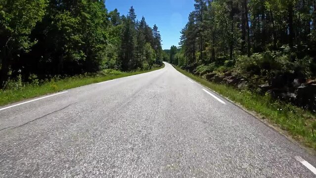 First person view of a nordic road, Norway, lush green contryside