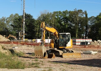 Excavators with bucket and shovel at work in a recently open contructon site.