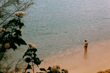 Una mujer en la playa mirando al mar