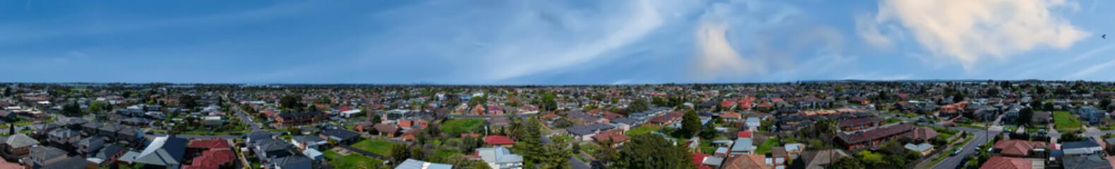 Fototapeta na wymiar Panoramic aerial Drone view of Melbournes suburbs and CBD looking down at Houses roads and Parks Victoria Australia. Beautiful colours at Sunset