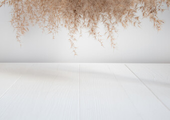 Advertising space with geometric shapes. Cylindrical wooden podium on a white background with pampas grass. A stage for a product demonstration, a showcase.