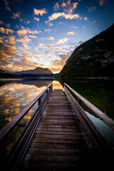 Breathtaking view of a jetty on the alpine Altausseer See (Lake Aussee) in Ausseer Land, Styria, Austria, with a stunning sunset in the background