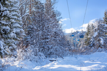 Bansko, Bulgaria winter resort with ski lift gondola cabins and snow mountains and trees after snowfall