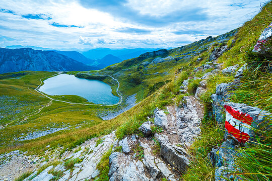 Great view of a trail marked with an Austrian flag around the Augstsee on the Loser mountain range, Ausseer Land, Salzkammergut, Styria, Austria