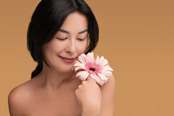 Obraz na płótnie Canvas Asian woman with clean skin holding flower