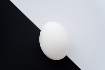 Top view of organic chicken egg on white and black background.