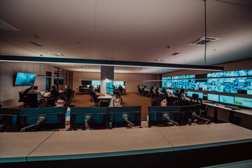 Group of Security data center operators working in a CCTV monitoring room looking on multiple monitors Officers Monitoring Multiple Screens for Suspicious Activities Team working on the System Contr