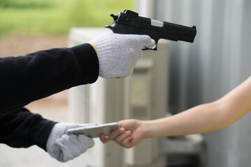Fototapeta robber pointing gun to woman and asking for money obraz