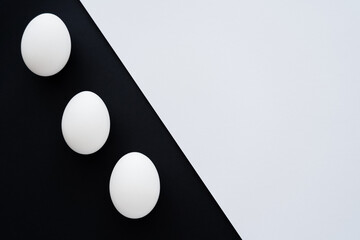 Top view of natural chicken eggs on white and black background.