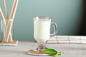 Kefir, fermented milk drink or yogurt in a glass on white wooden background.