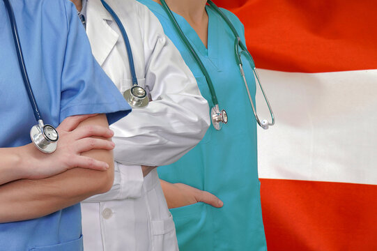 Three Doctors with stethoscope in standing on Austria flag background. Close-up medical team. Group of doctors. Innovative technologies in science and medicine, medical development in Austria