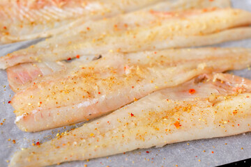 Delicious fresh fish hake fillet with spices and herbs
