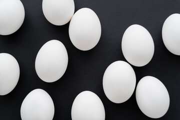 Top view of white chicken eggs isolated on black.