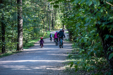 family on bikes in the park on sunday sunny day