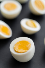 Close up view of cut boiled chicken egg on black background.