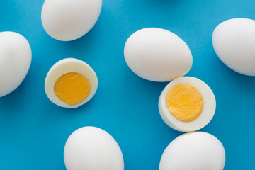 Top view of cut boiled eggs on blue background.