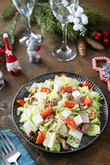Winter Christmas salad. Delicious Salad with chinese cabbage, feta, cherry tomatoes and canned tuna on a festive table.