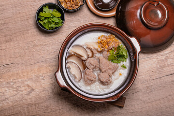 Fototapeta na wymiar Pork porridge with shiitake mushrooms in brown cups topped with coriander and fried garlic
