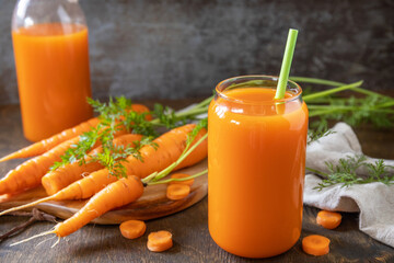 Healthy food concept, fresh natural juice. Glass jar of fresh carrot juice with fresh carrots on a...