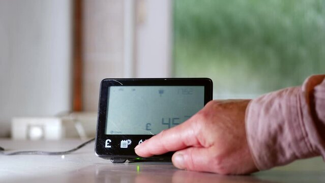 Checking home smart meter displayed on kitchen counter