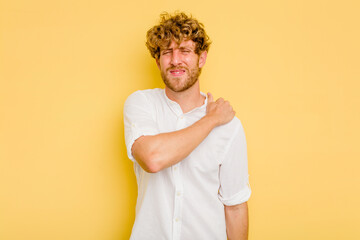 Young caucasian man isolated on yellow background having a shoulder pain.