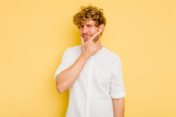 Young caucasian man isolated on yellow background contemplating, planning a strategy, thinking...