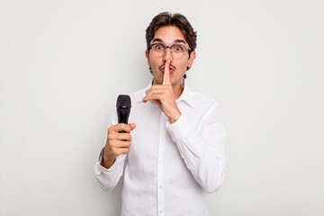 Naklejka premium Young hispanic singer man isolated on white background keeping a secret or asking for silence.