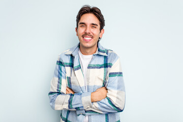 Young hispanic man isolated on blue background laughing and having fun.