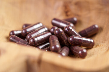 Purple capsules with blueberries in a rustic dish