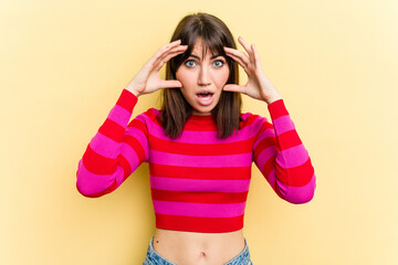 Young caucasian woman isolated on yellow background receiving a pleasant surprise, excited and raising hands.