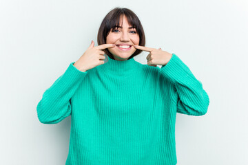 Young caucasian woman isolated on white background smiles, pointing fingers at mouth.