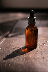 organic cosmetic product in glass brown bottle with pipette on sunlight