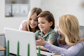 Fototapeta na wymiar Single mother with two kids watching something on laptop