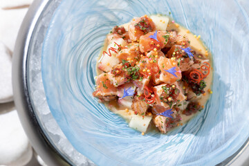 fish salad in a blue plate on a white background