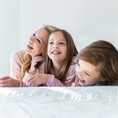 Family spending time together in bedroom, playing games, and playing with their dog