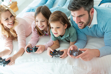 Family spending time together in bedroom, playing games, and playing with their dog
