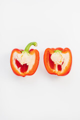 Fresh ripe sweet red bell pepper cut in half on white background