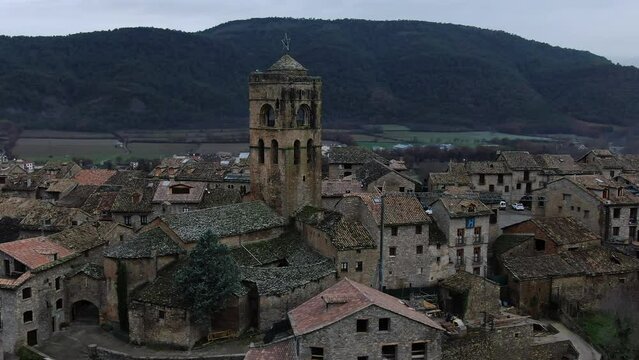 aerial shot in orbit and close to the tower of the medieval town Ainsa in Huesca. Province of Aragon, Spain.