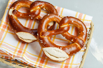 Two traditional soft Octoberfest pretzels in bread basket, close-up
