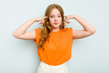 Young caucasian woman isolated on blue background focused on a task, keeping forefingers pointing head.