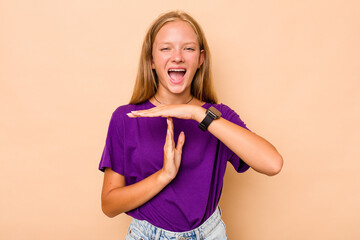 Caucasian teen girl isolated on beige background showing a timeout gesture.