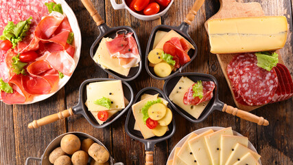 traditional raclette cheese party with various ham