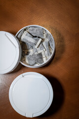 Snus,  moist powder tobacco product , close-up vertical image with no label box