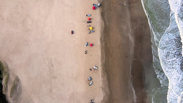 Drone shot of a beach from above in Caril&oacute;, Argentina, following a car.