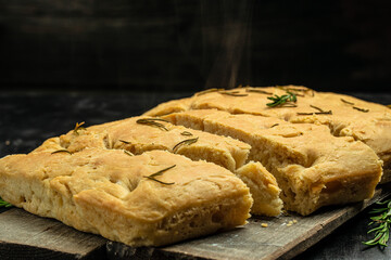 Hot Italian bread traditional pieces of focaccia. Traditional Italian Focaccia with rosemary. Food recipe background. Close up