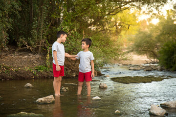 two brothers look at each other and enjoy an excursion on the river