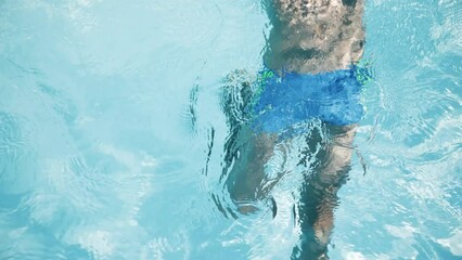 4k video Portrait of handsome boy in glasses in swimming pool, child enjoying swimming in summer in pool. Vacation hotel concept.