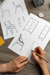 Hands of an artist sketching furniture. Creation of design of chairs and cabinets for the interior. - 531657522