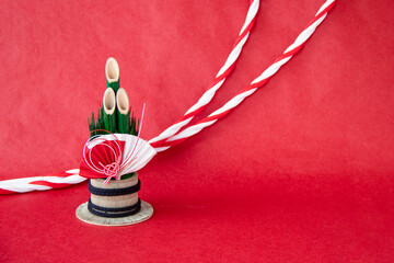 日本の正月イメージ　扇のついた門松と紅白の水引の紐（赤バック）